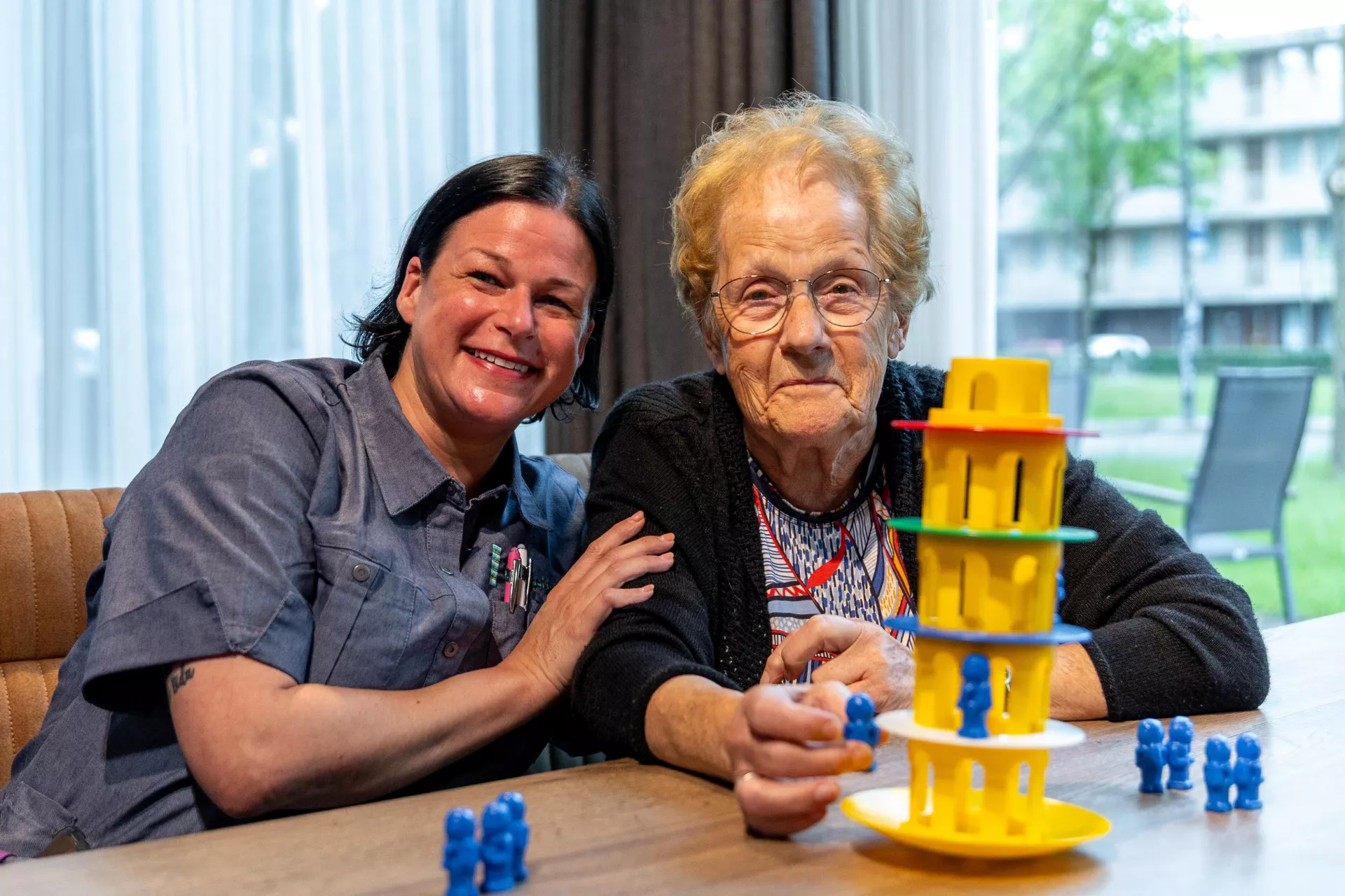 Twee vrouwen spelen samen een spel aan tafel.